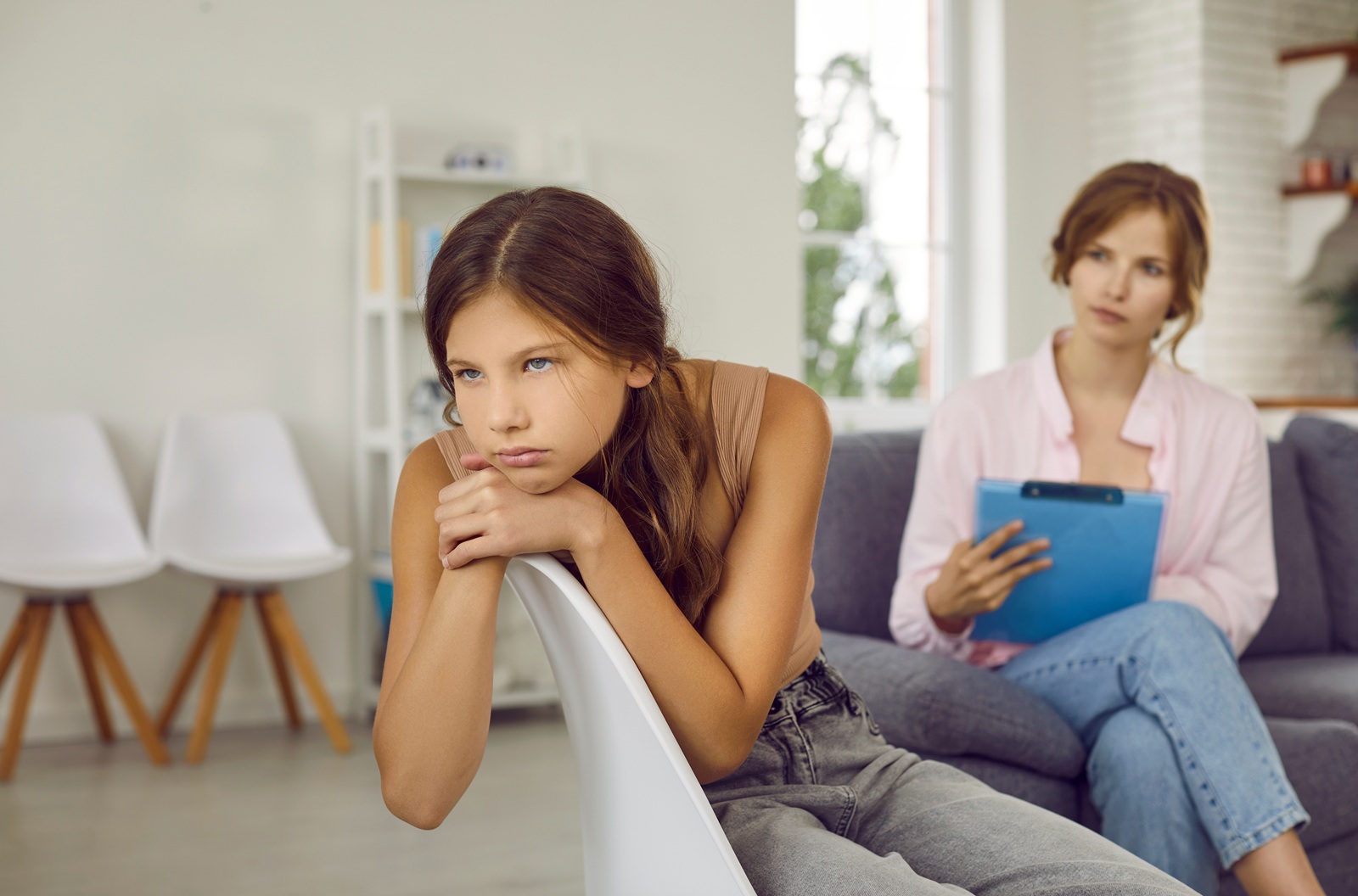 Parent and teenager reviewing a weekly homework planner together at a kitchen table
