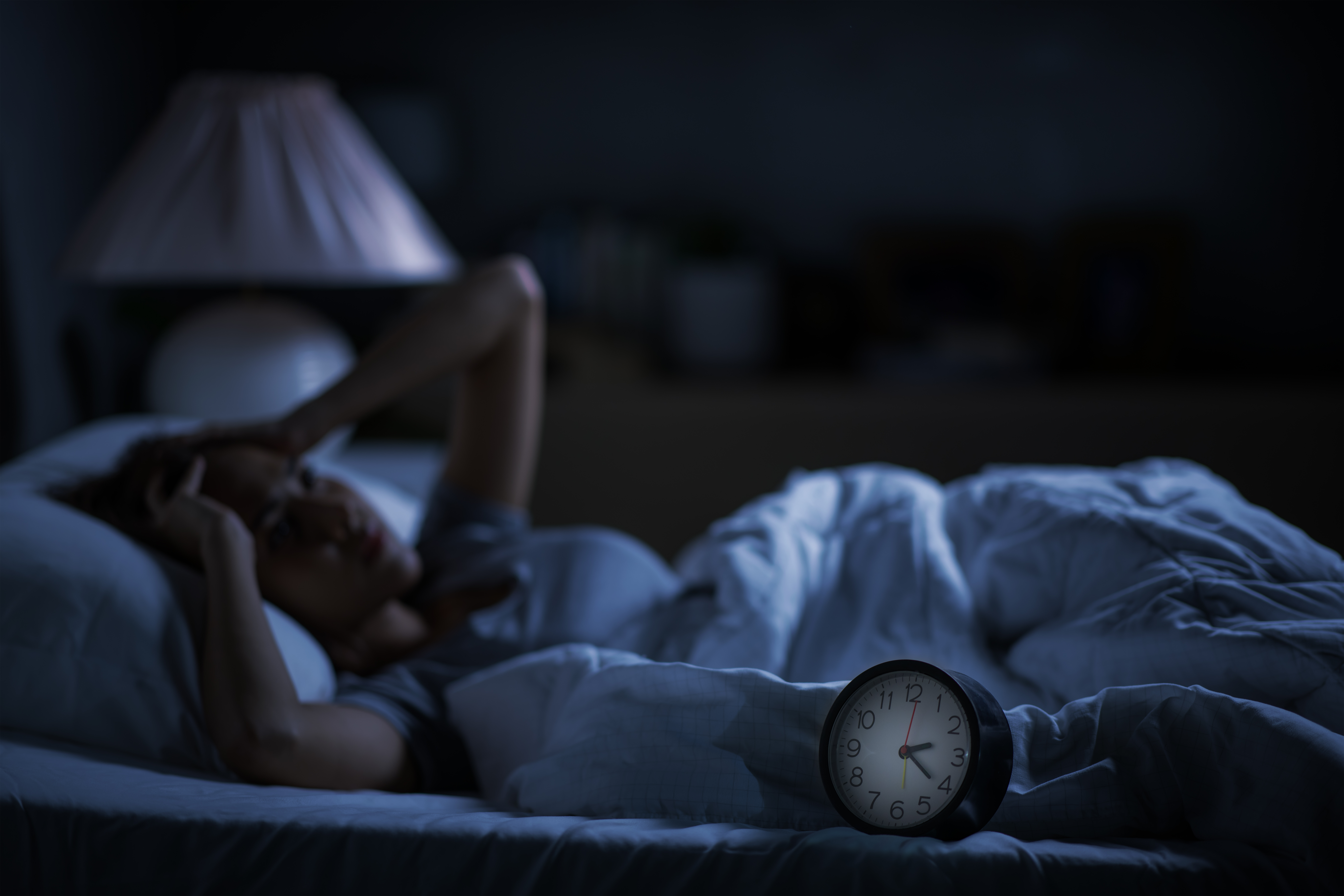 Person lying awake at night experiencing depression-related insomnia